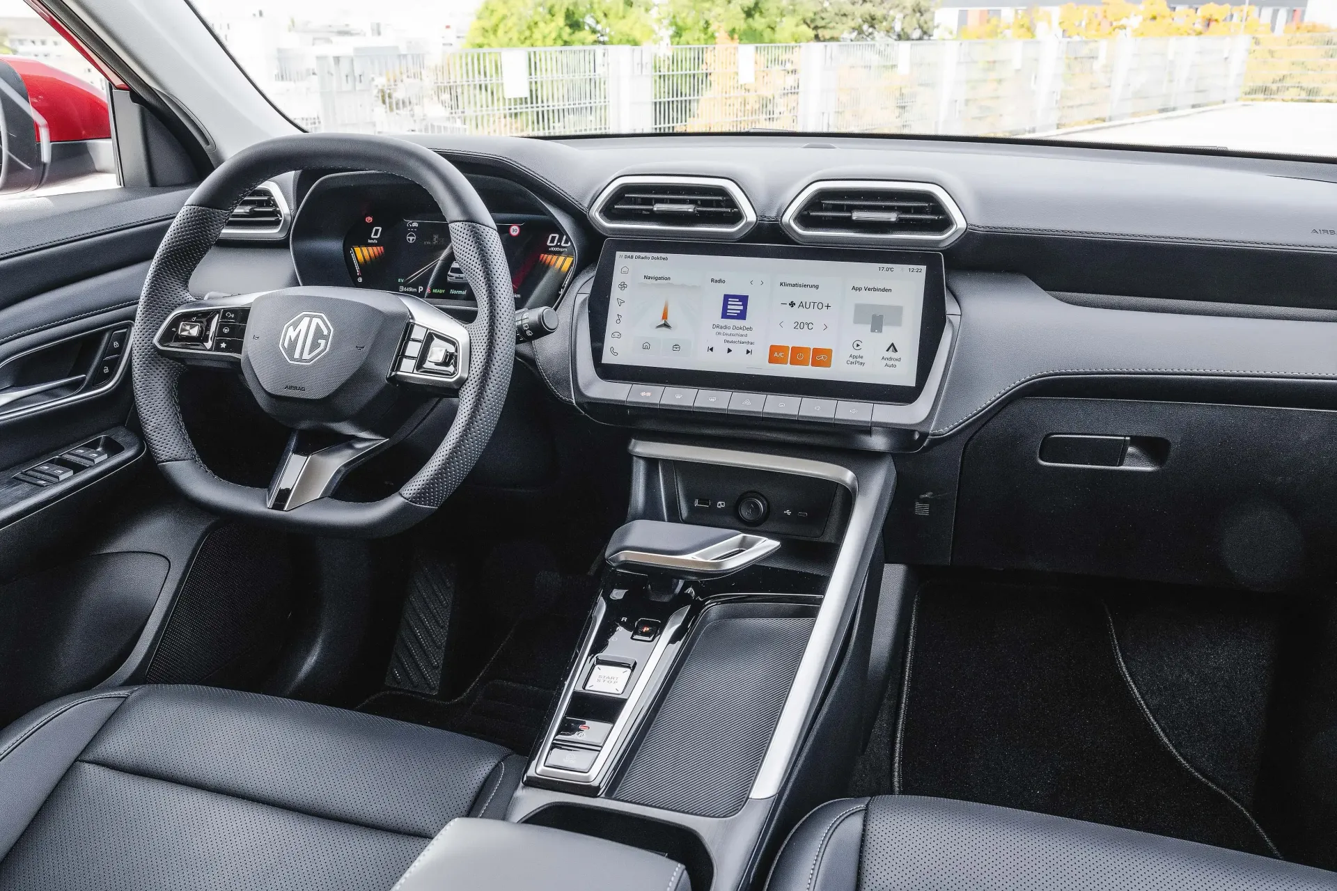 Car interior with black seats, steering wheel, dashboard, and central touchscreen display