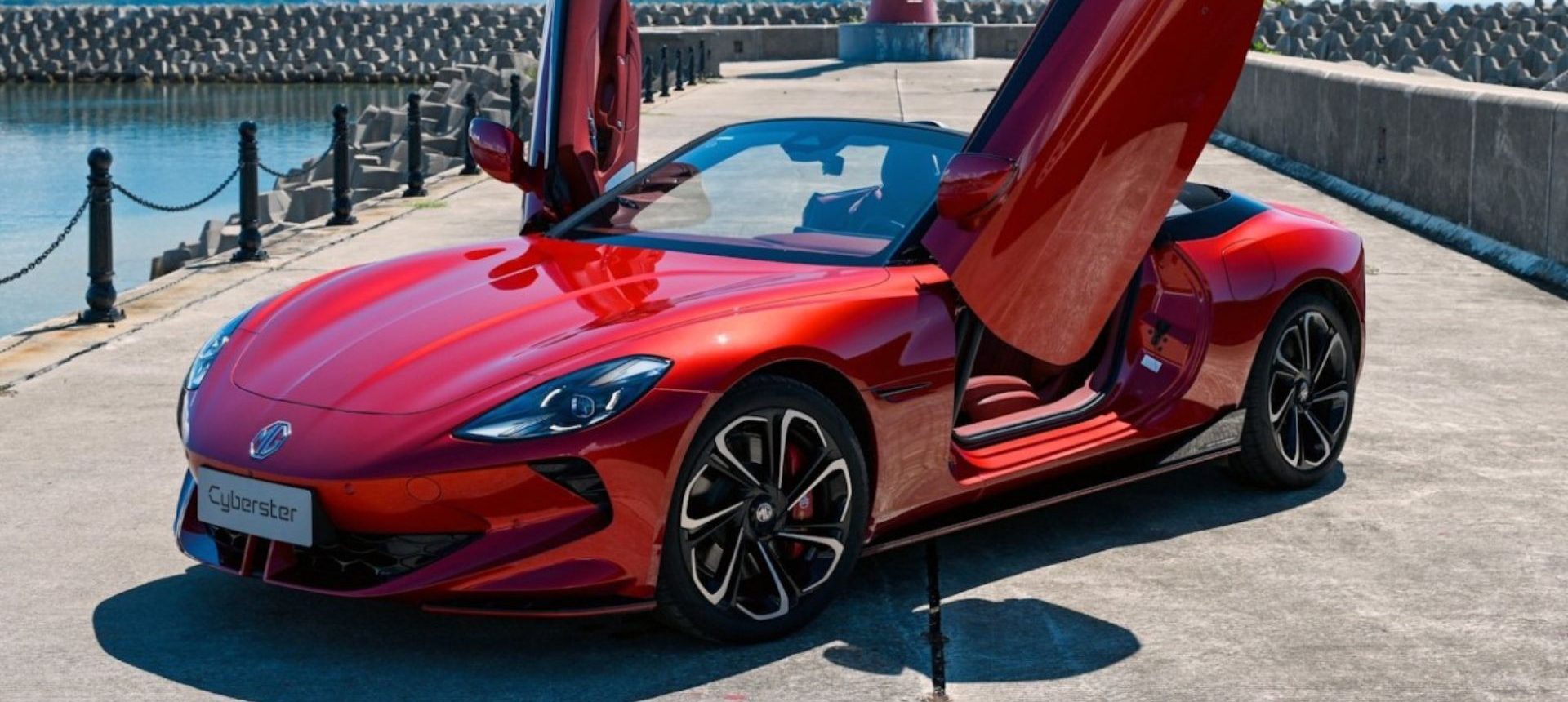 Red sports car with butterfly doors open in a garage, glossy red finish and black accents