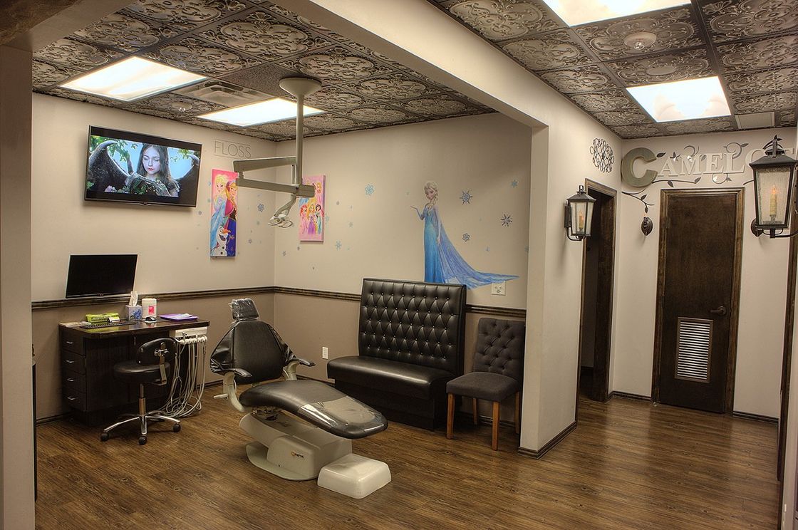 Modern tattoo studio with chairs, wall art, screens, and wooden floors