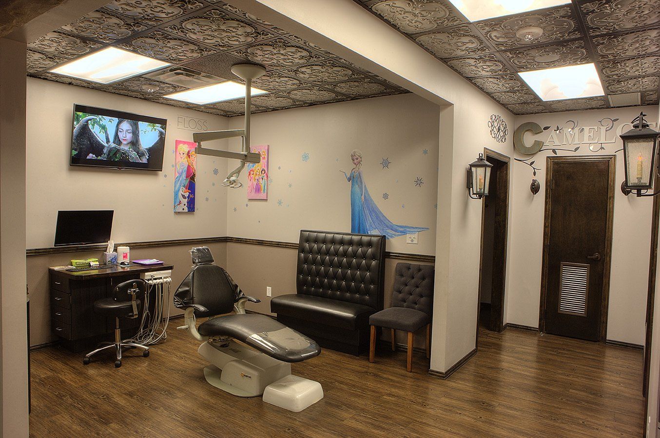 Modern tattoo studio with chairs, wall art, screens, and wooden floors