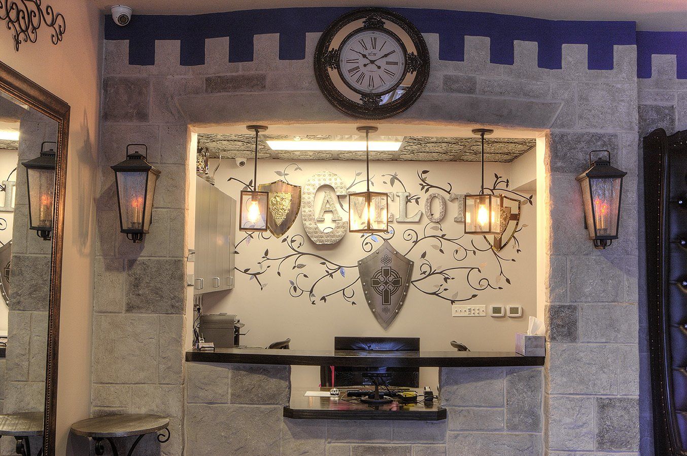 Decorative wall reception desk with clock, lanterns, and stone archway in warm lighting