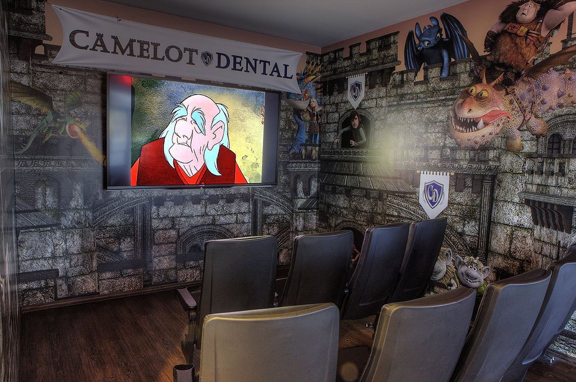 Dentist waiting room with a TV on the wall and several dark chairs facing it