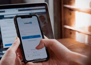 Person holding a smartphone with LinkedIn login page