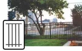 Black metal gate and fence in a grassy yard with trees and a building in the background