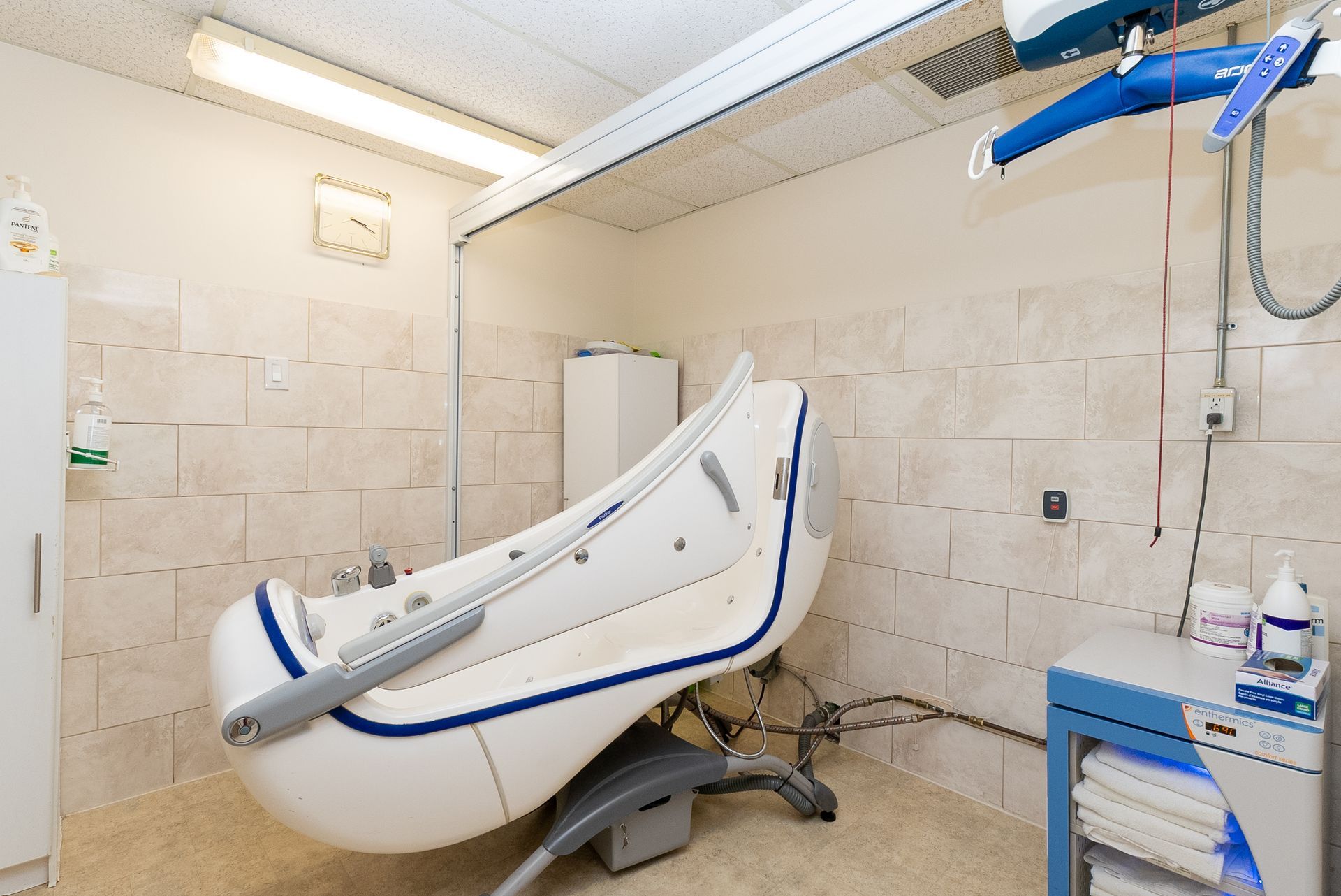 Accessible lift chair in a tiled bathroom with a roll-in shower area