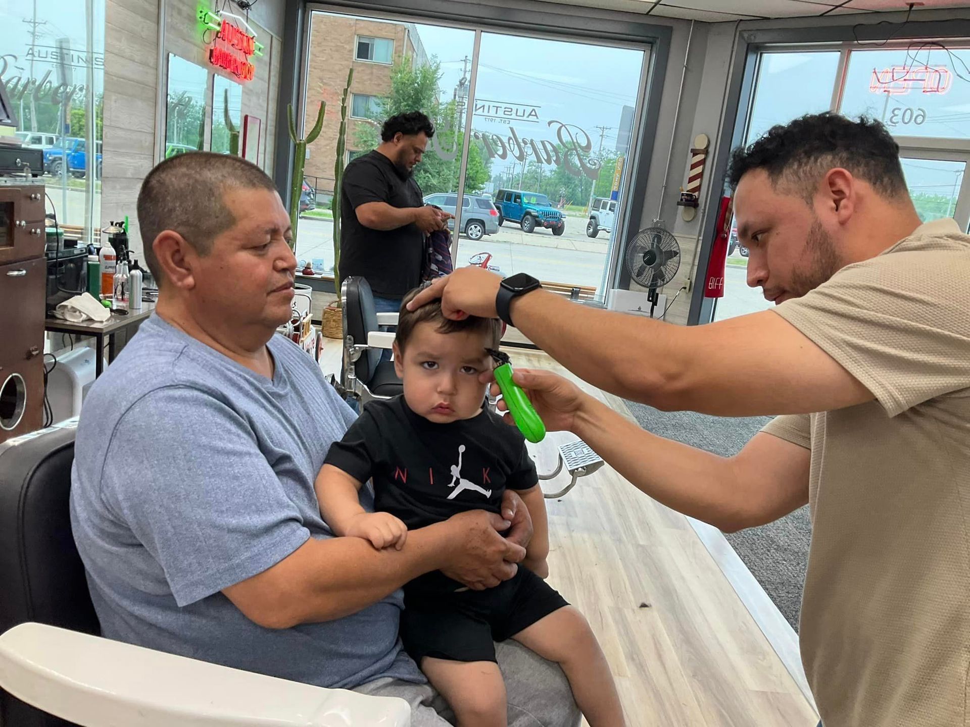 A boy is getting his hair cut in a barber shop