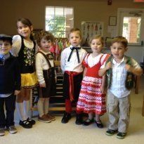 Group of children in various costumes, indoors.