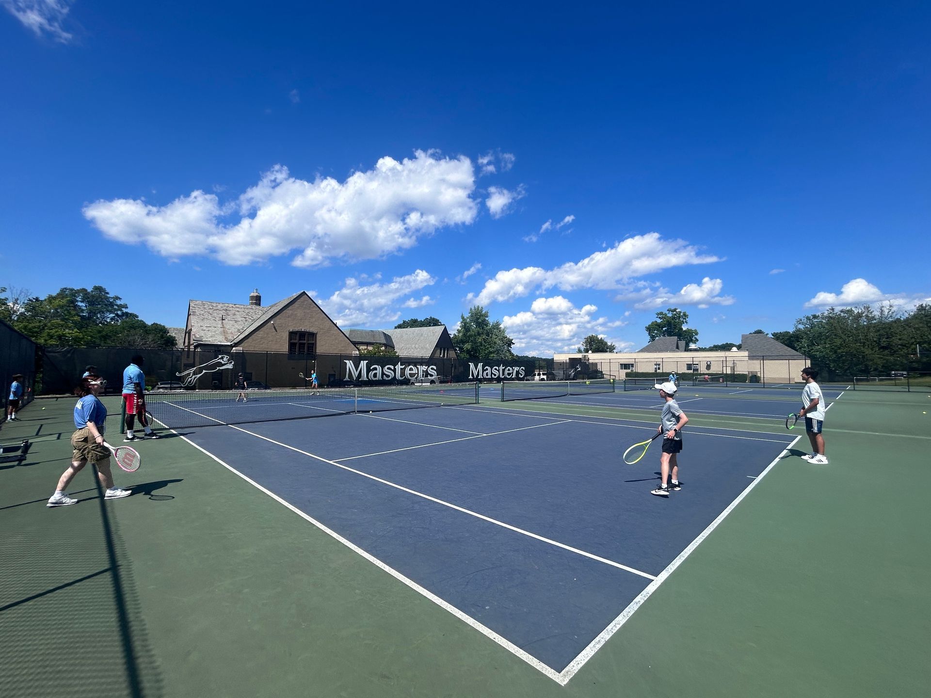 A group of people are playing tennis on a masters tennis court