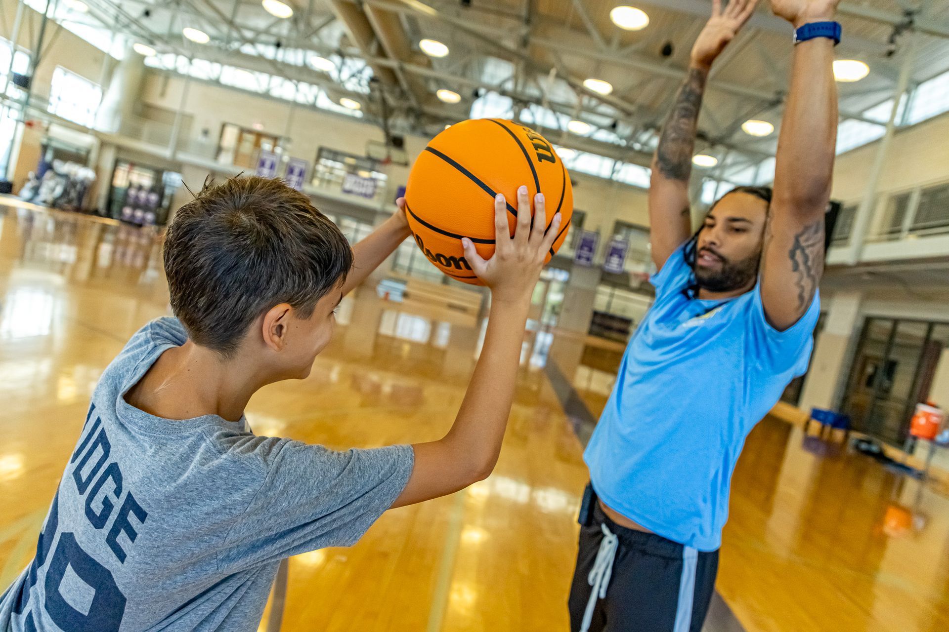A group of children are playing basketball in a gym