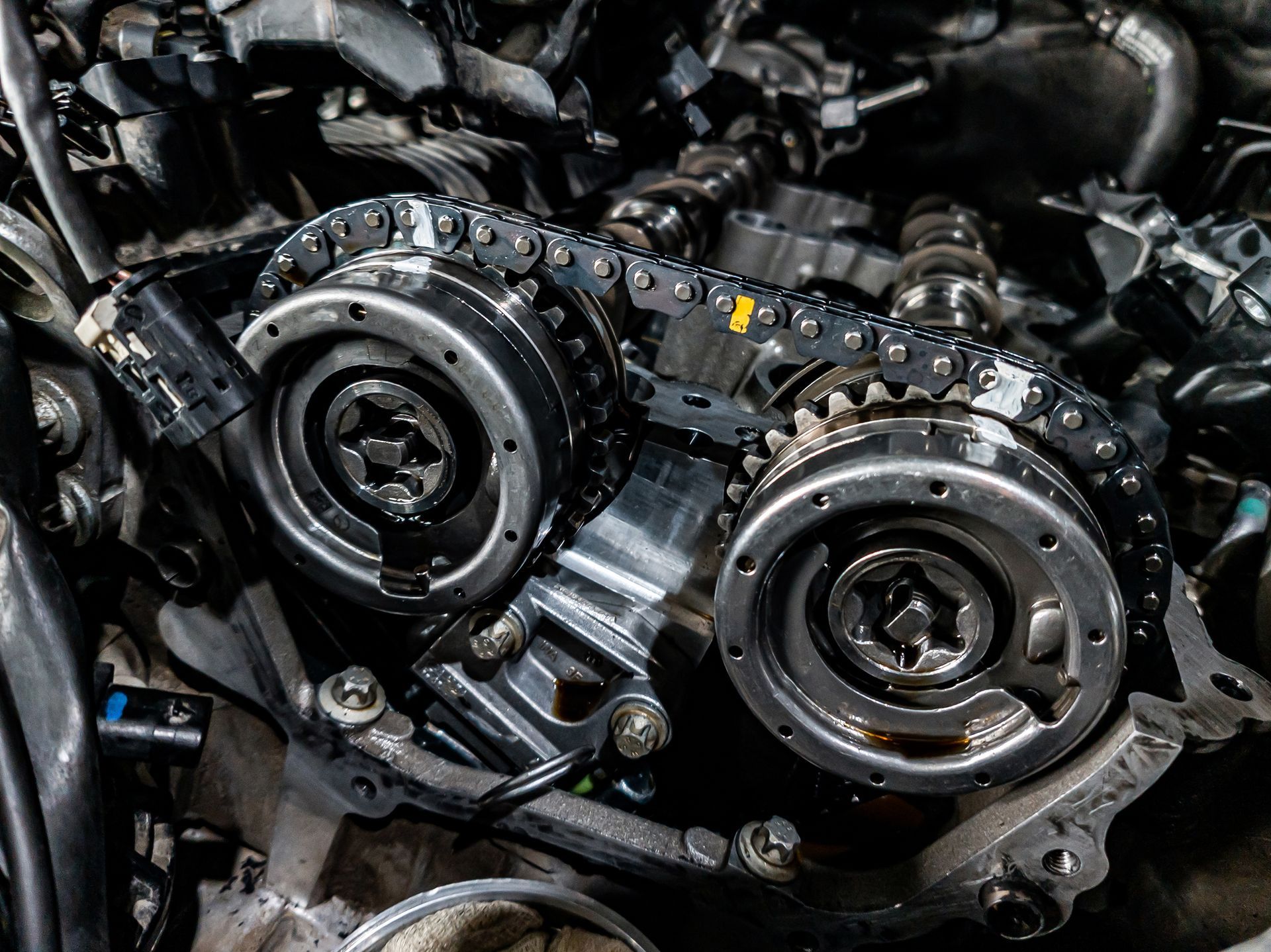 Close-up of car engine parts: gears, chains, and sprockets.