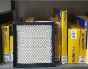 Air filter in front of boxes of car parts on a shelf.