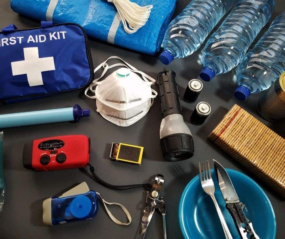 Emergency preparedness kit with first aid, water, masks, radio, flashlight, food, and utensils.