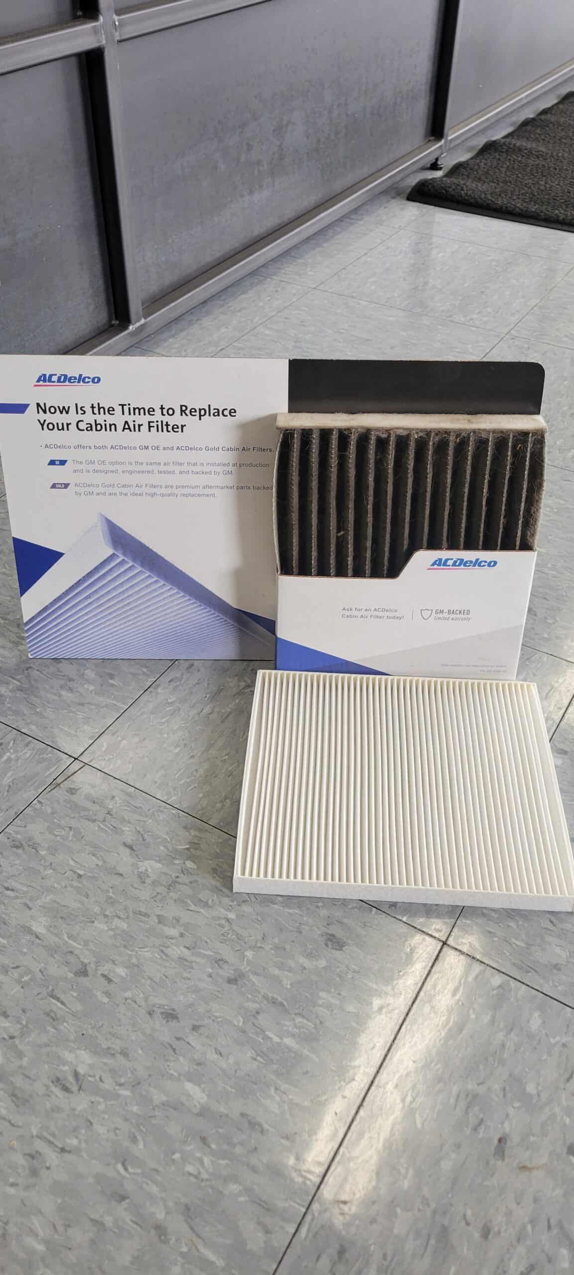 Car air filter set on a tiled floor, with box and two filters.