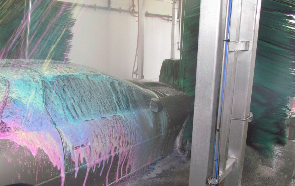 A car is covered in foam at a car wash.