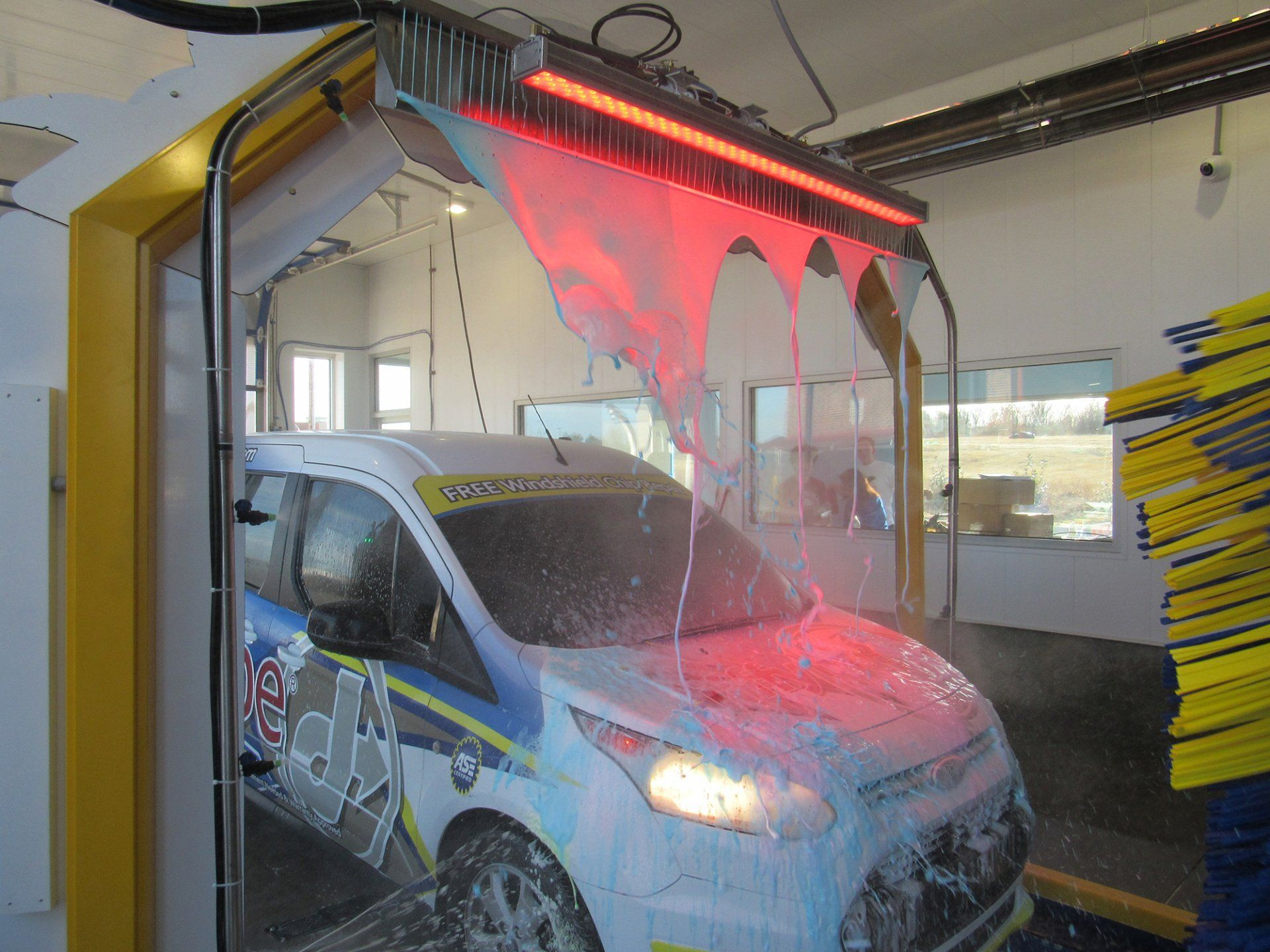A white van is being washed in a car wash