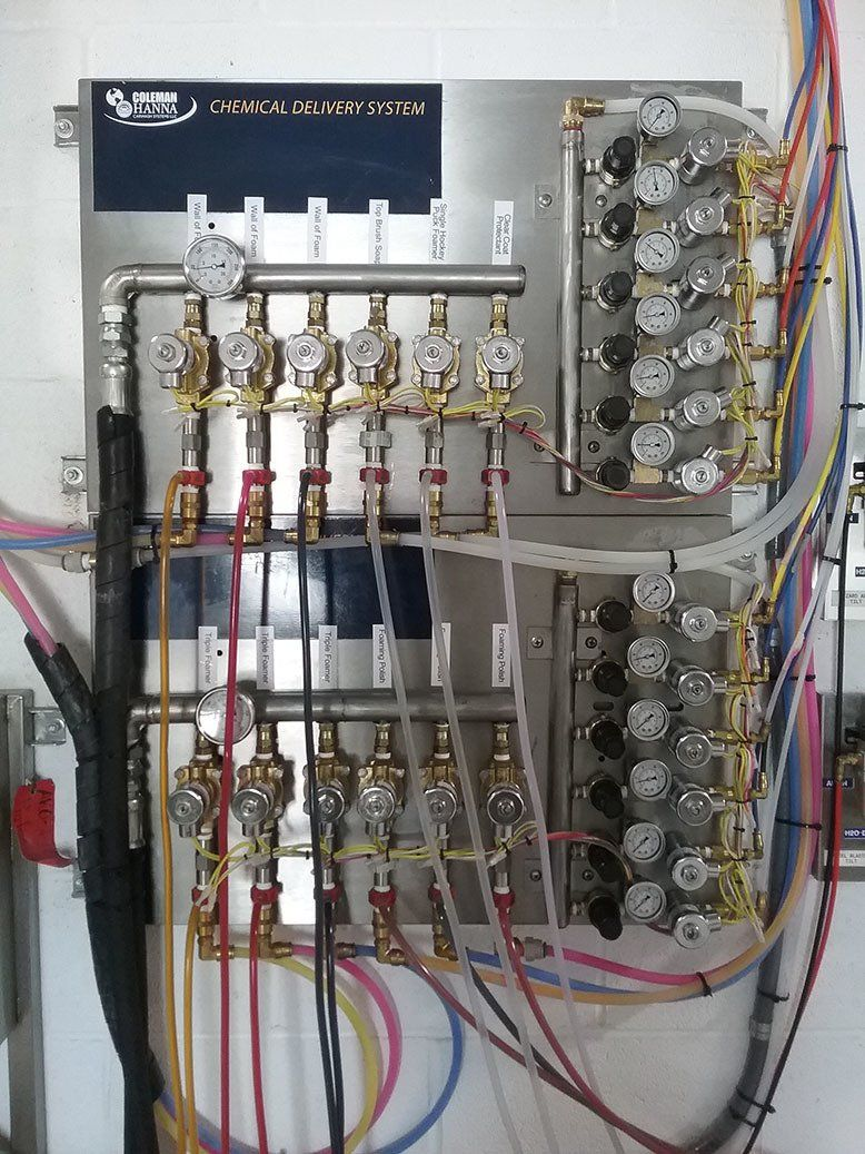 A wall with a bunch of wires hanging from it.