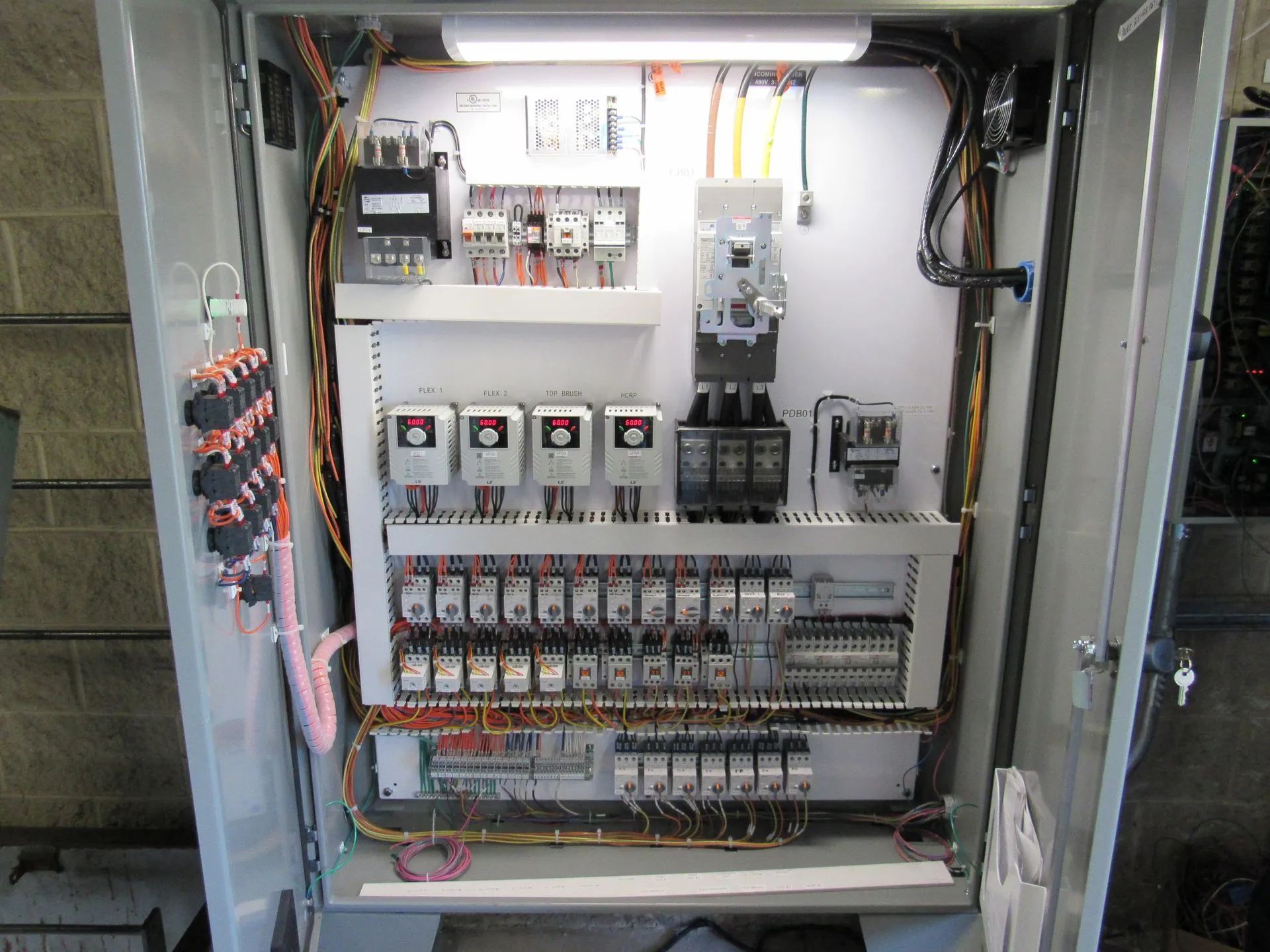 The inside of a control panel with a lot of wires