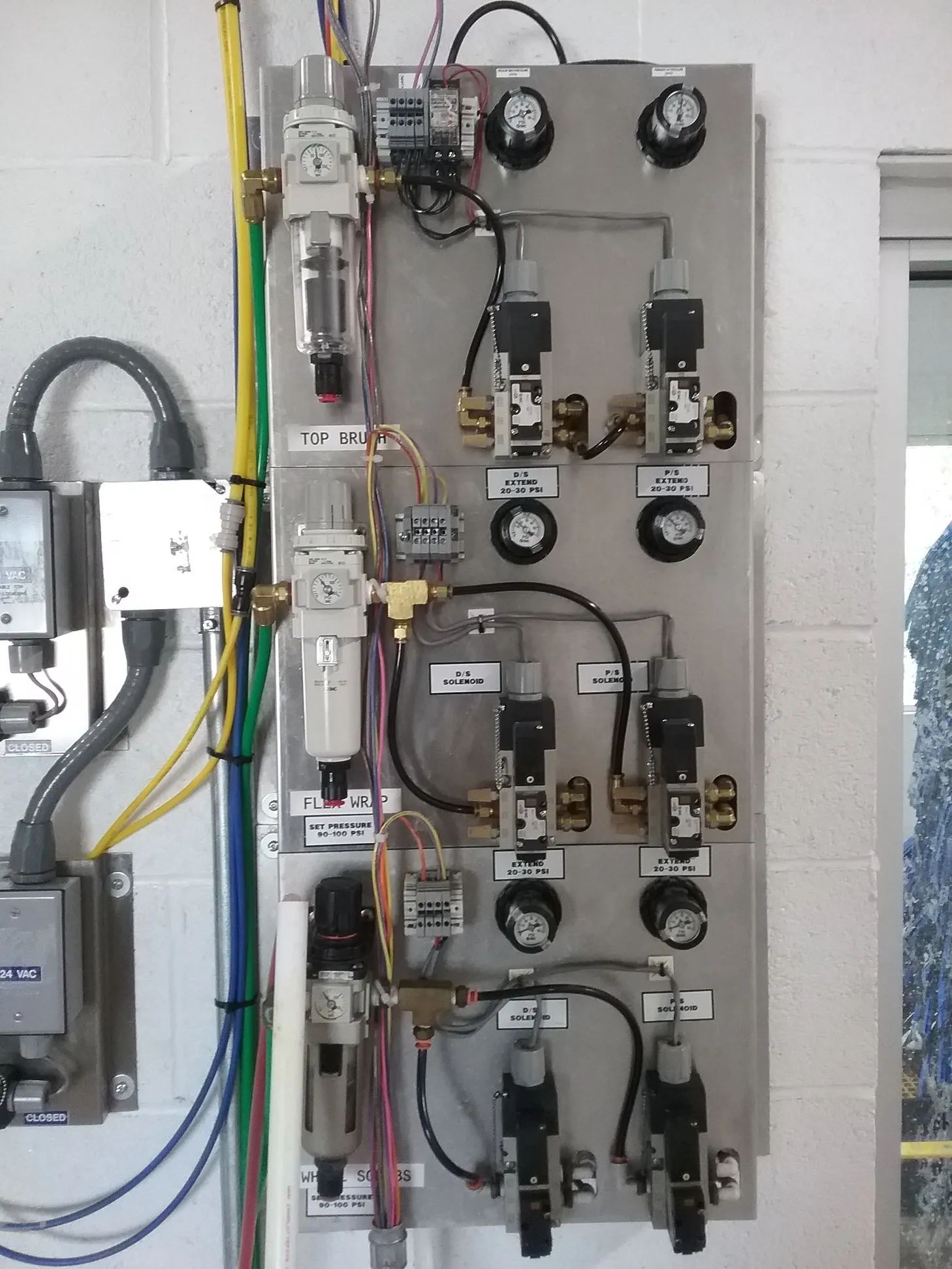 A wall with a bunch of wires and valves on it