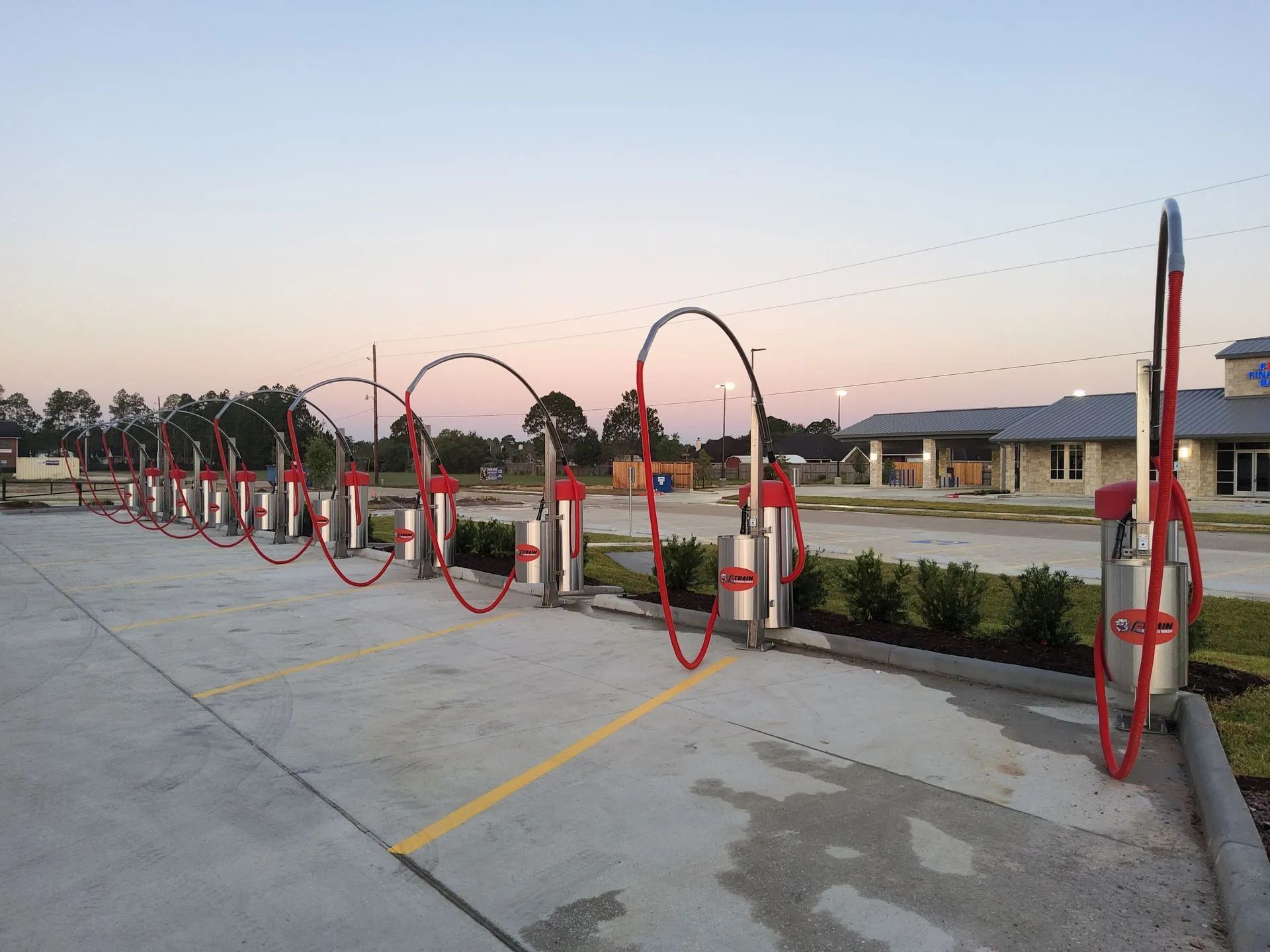 A row of gas pumps are lined up in a parking lot.