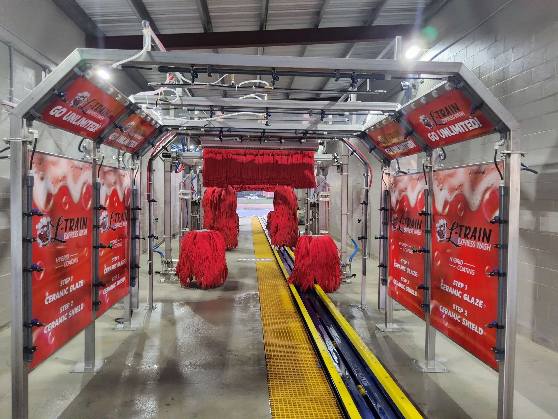 A car wash with a lot of red sponges on the walls.