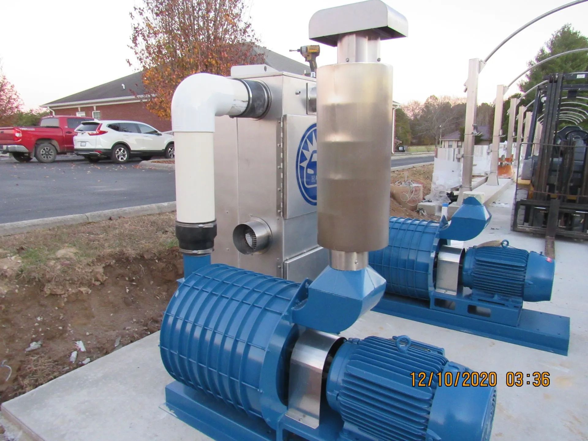 Two blue pumps are sitting next to each other in a parking lot