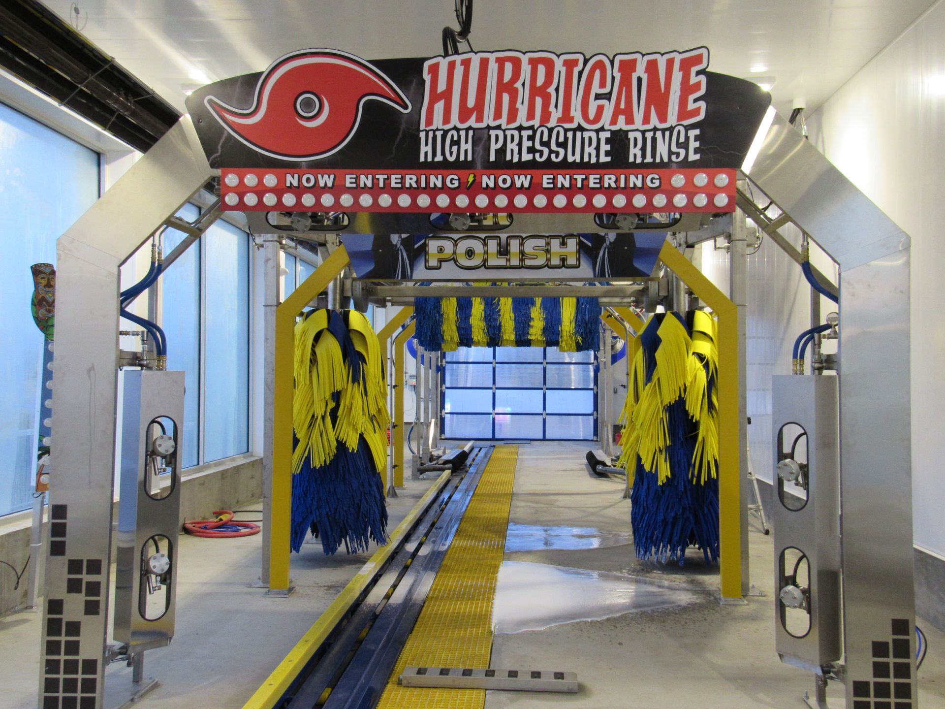 Interior of a car wash, showing the wash equipment with colorful brushes and a 