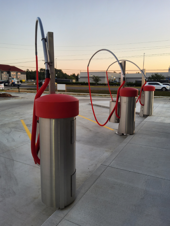 Car wash vacuum stations with red hoses and stainless steel posts at dusk