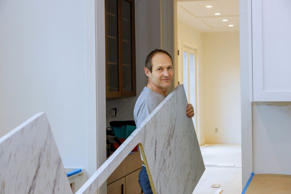 Man Installing Cabinet — Twin Cities, MN — Top Shelf Painting & Services Man Installing Cabinet — Twin Cities, MN — Top Shelf Painting & Services