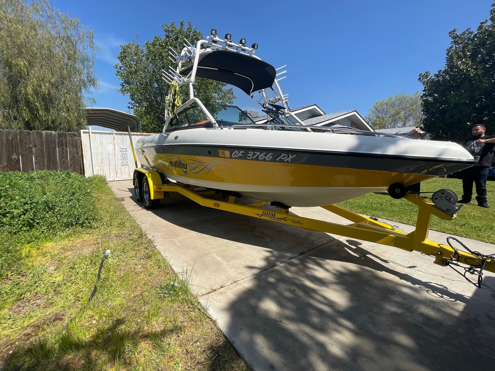 A boat is sitting on a trailer in a driveway.