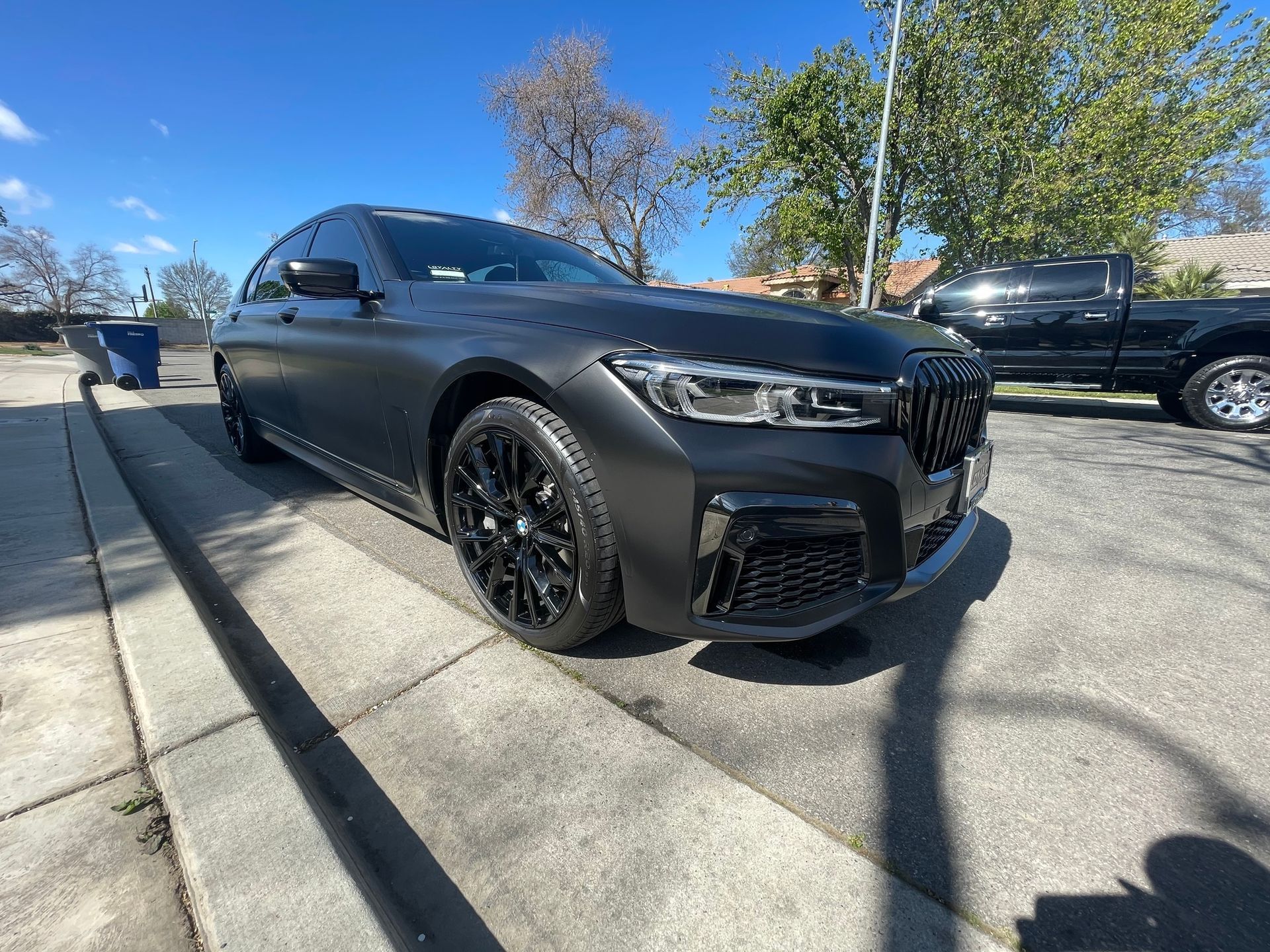 A black car is parked on the side of the road.