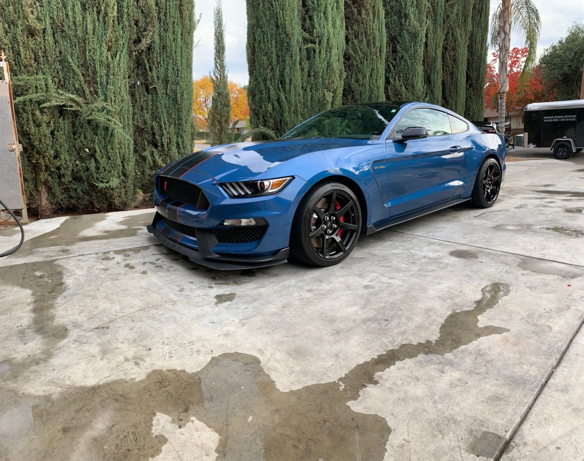 A blue ford mustang is parked in a parking lot.