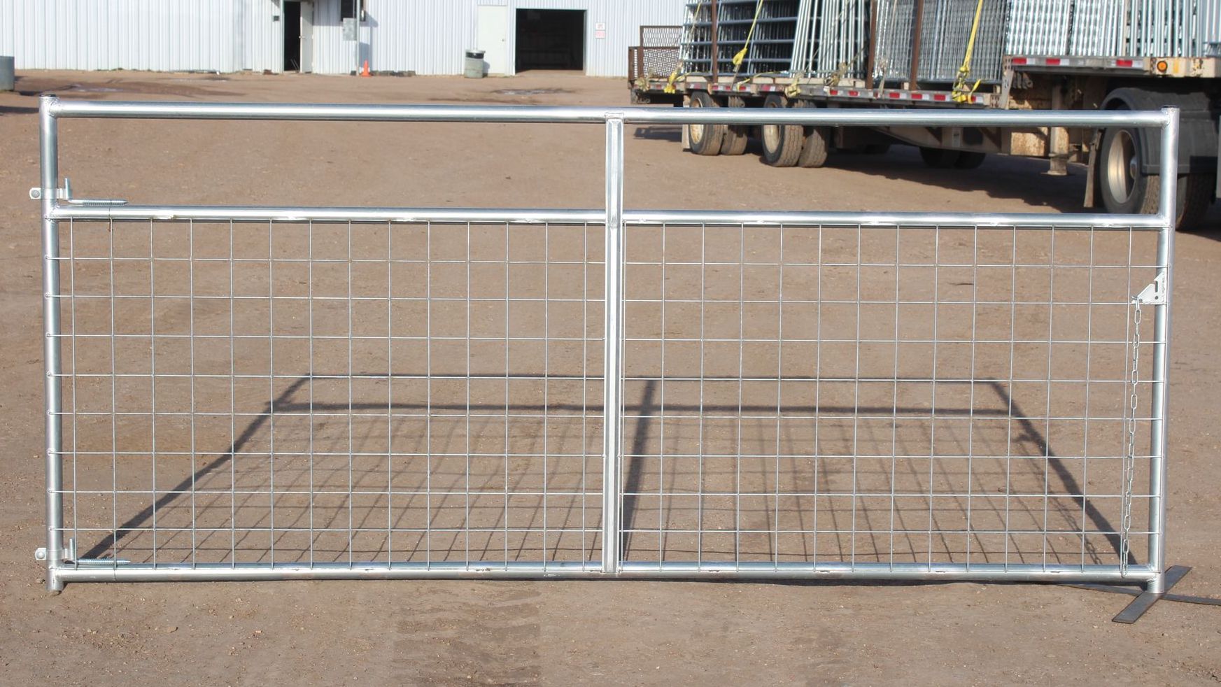 A metal gate is sitting on the ground in front of a truck