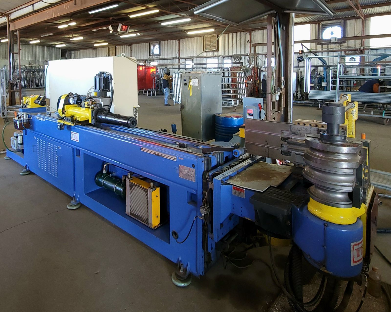 A blue and yellow machine is sitting in a warehouse.