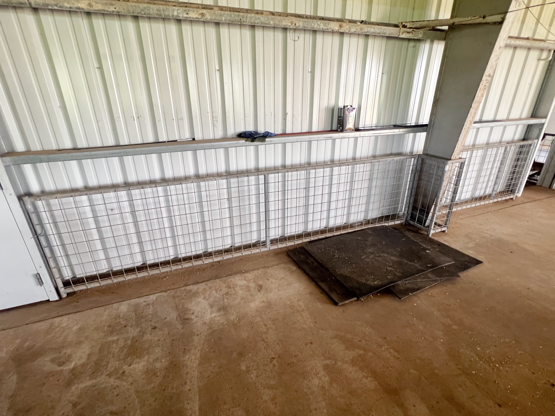 A metal fence is sitting on the ground in a building.