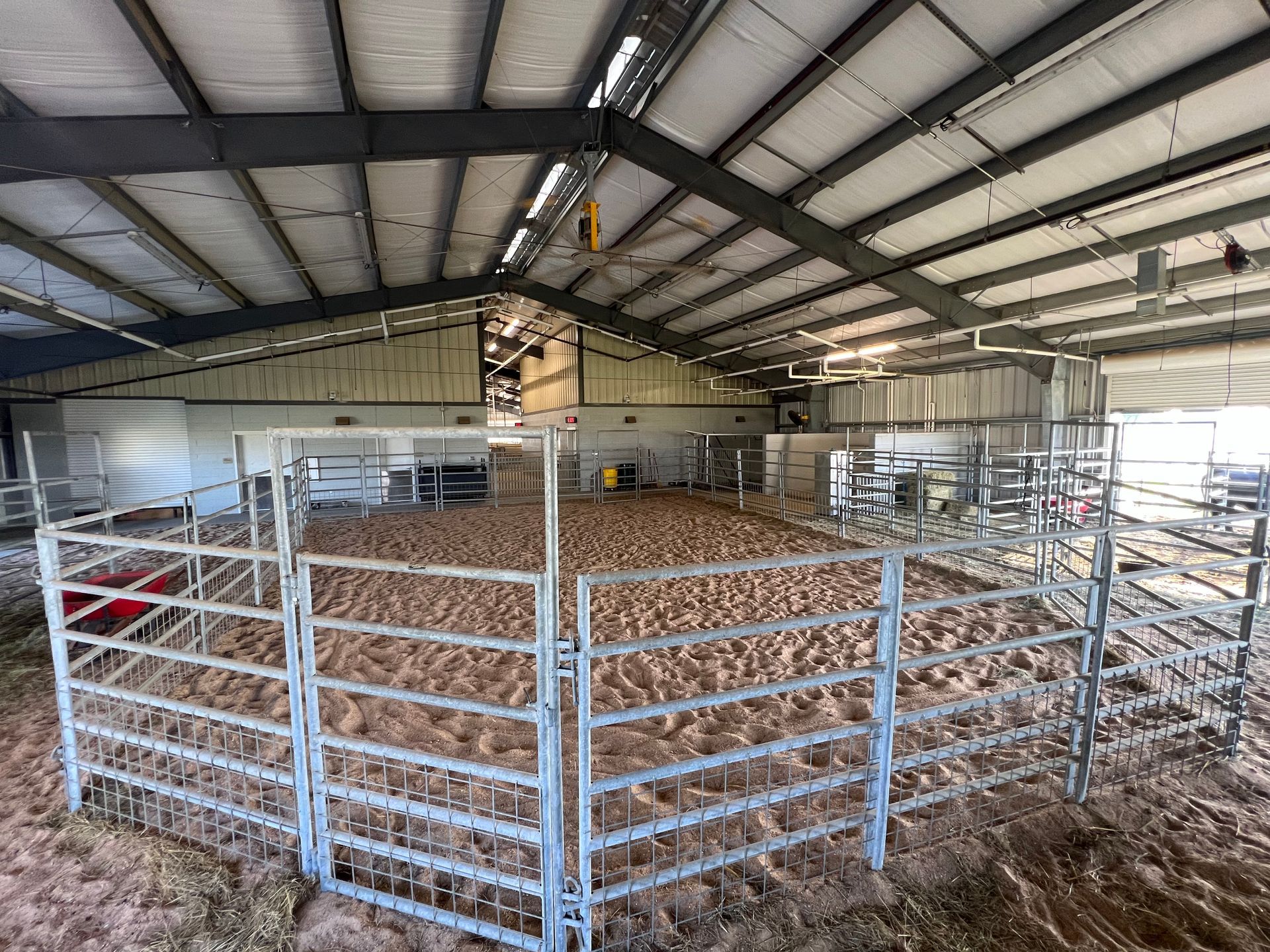 A large indoor arena with a metal fence around it.