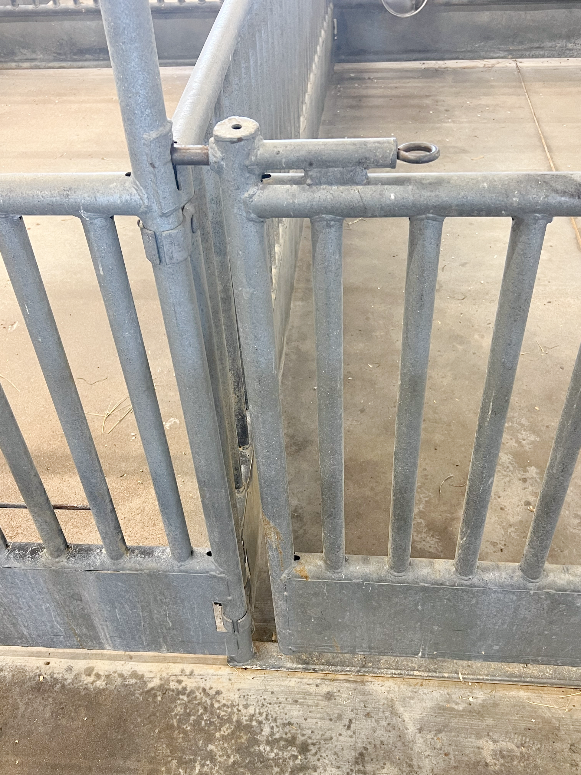 A close up of a metal fence with a door open.