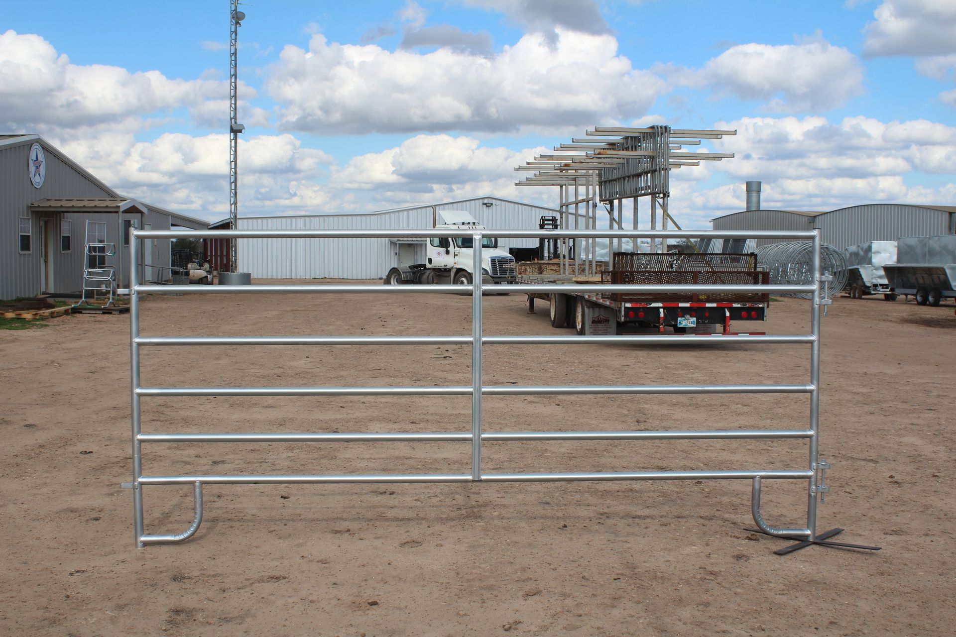 A metal fence is sitting on top of a dirt field.