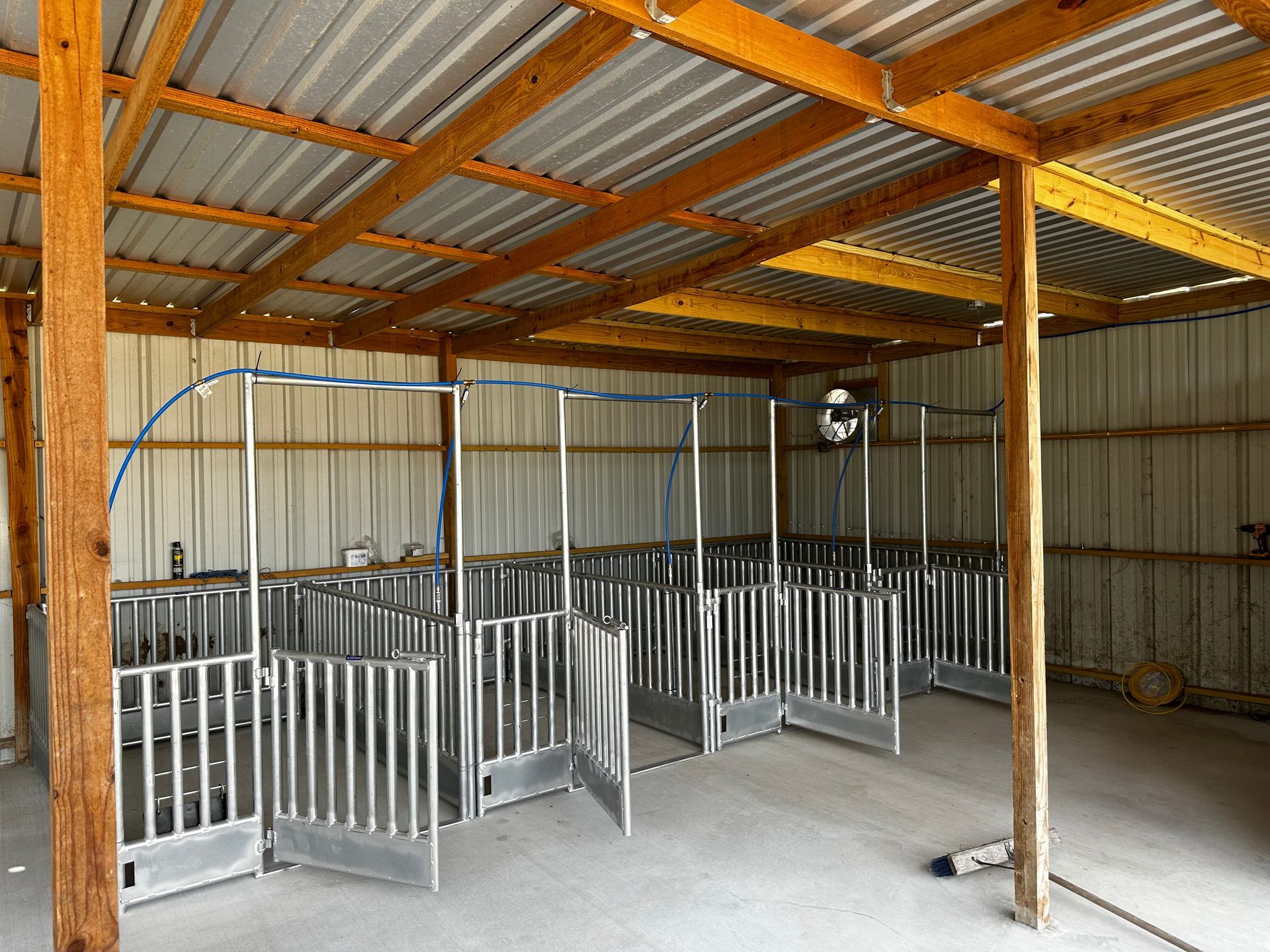 The inside of a barn with a metal roof and wooden beams.