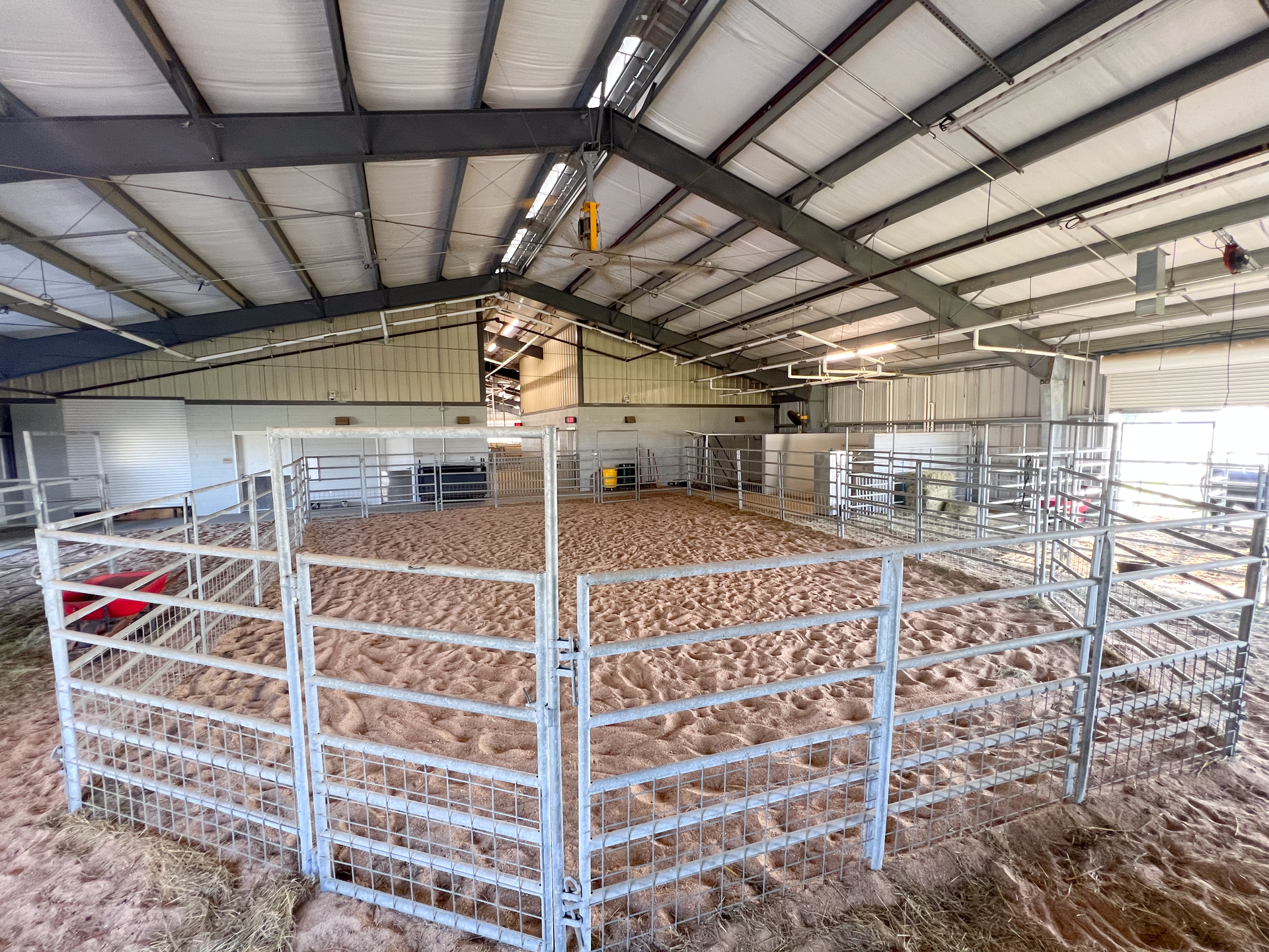 A large indoor arena with a metal fence around it.