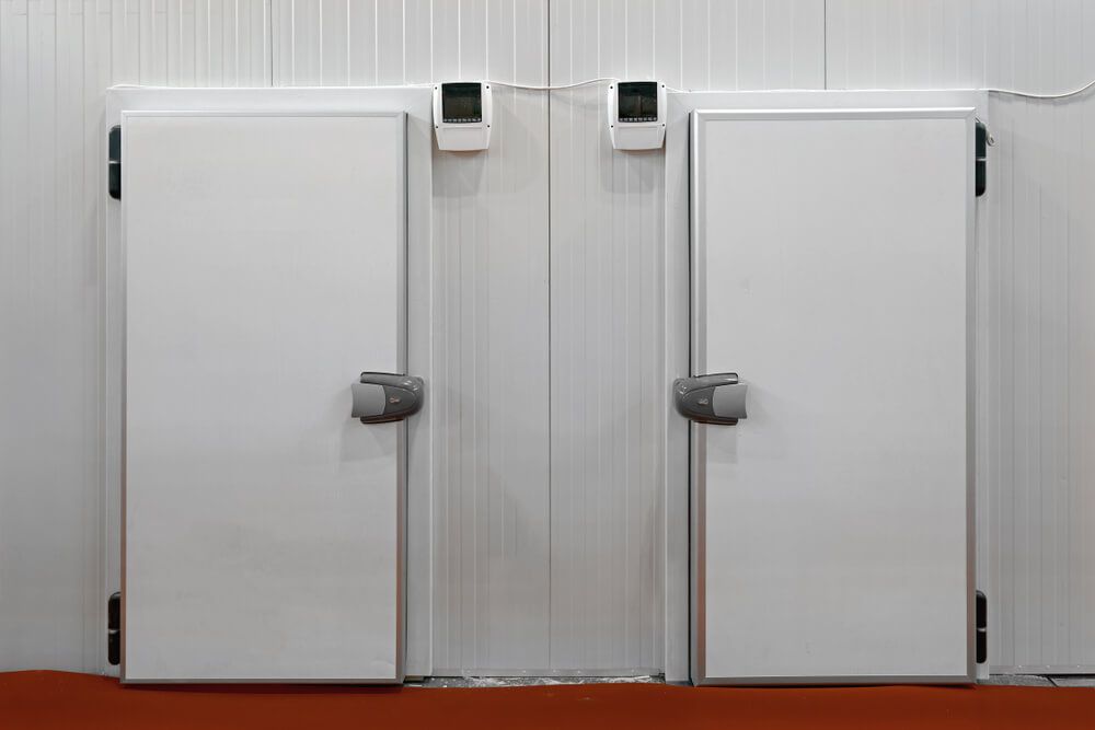 A Couple of White Doors in A Room with A Red Floor — Care Mechanical Services in Wagga Wagga, NSW