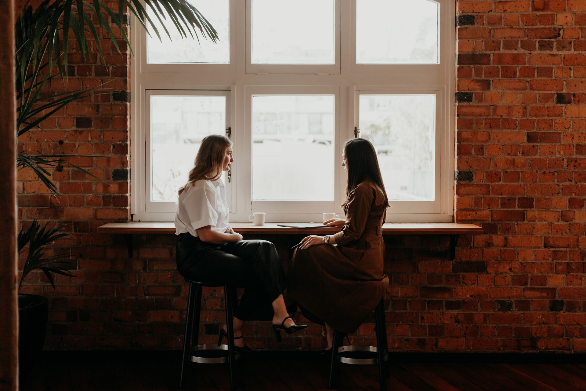 Polina Kozlova talking with a colleague by the window at PK Law