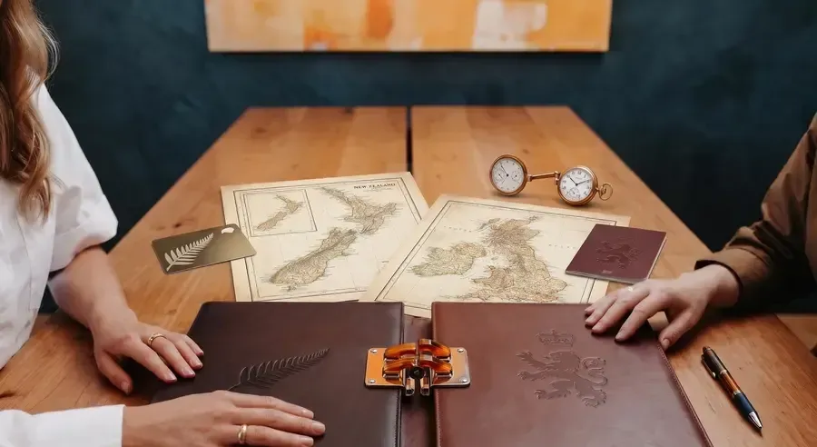 Old maps, a passport and a pen on a desk, illustrating cross-border wills