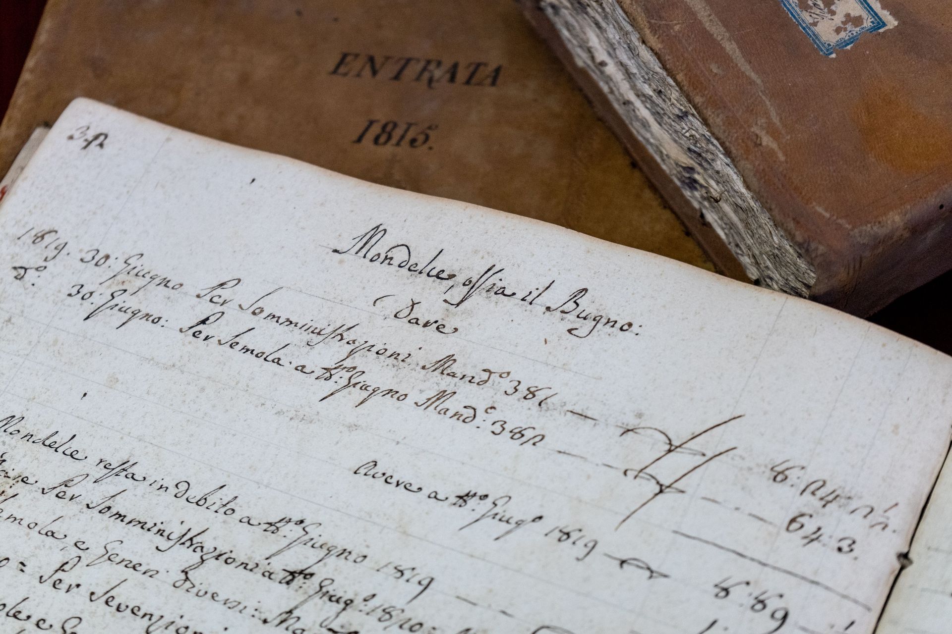 Close-up of a handwritten ledger page in front of a wooden box labeled 1816.