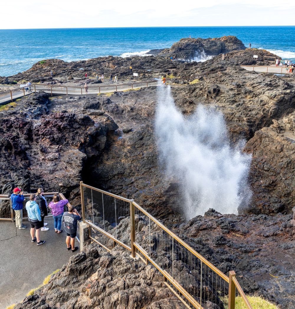A group of people views a spray of water