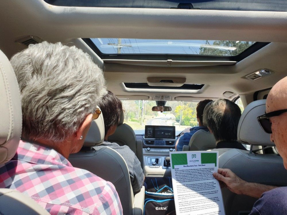 A group of people are sitting in a car reading a book.