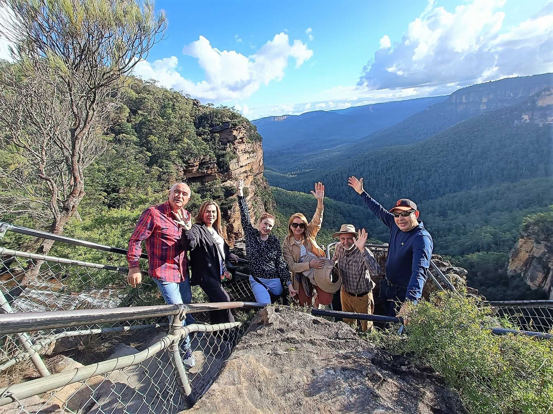 A group of people are posing for a picture on top of a mountain.