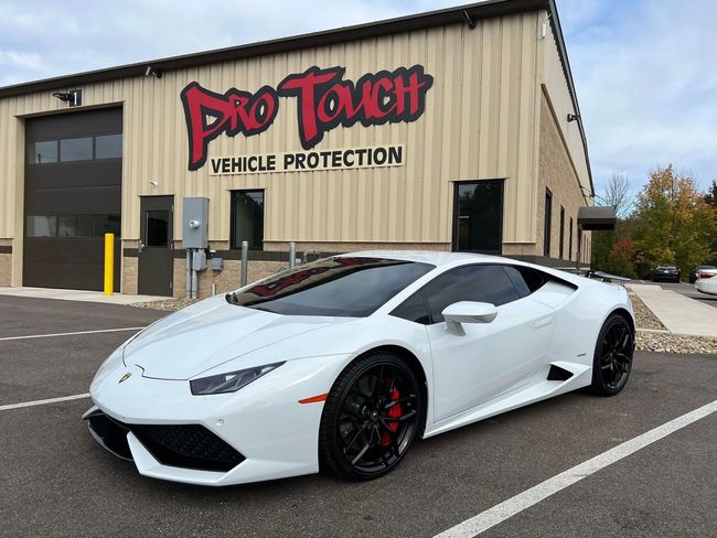 White Lamborghini parked in front of Pro Touch Vehicle Protection building.