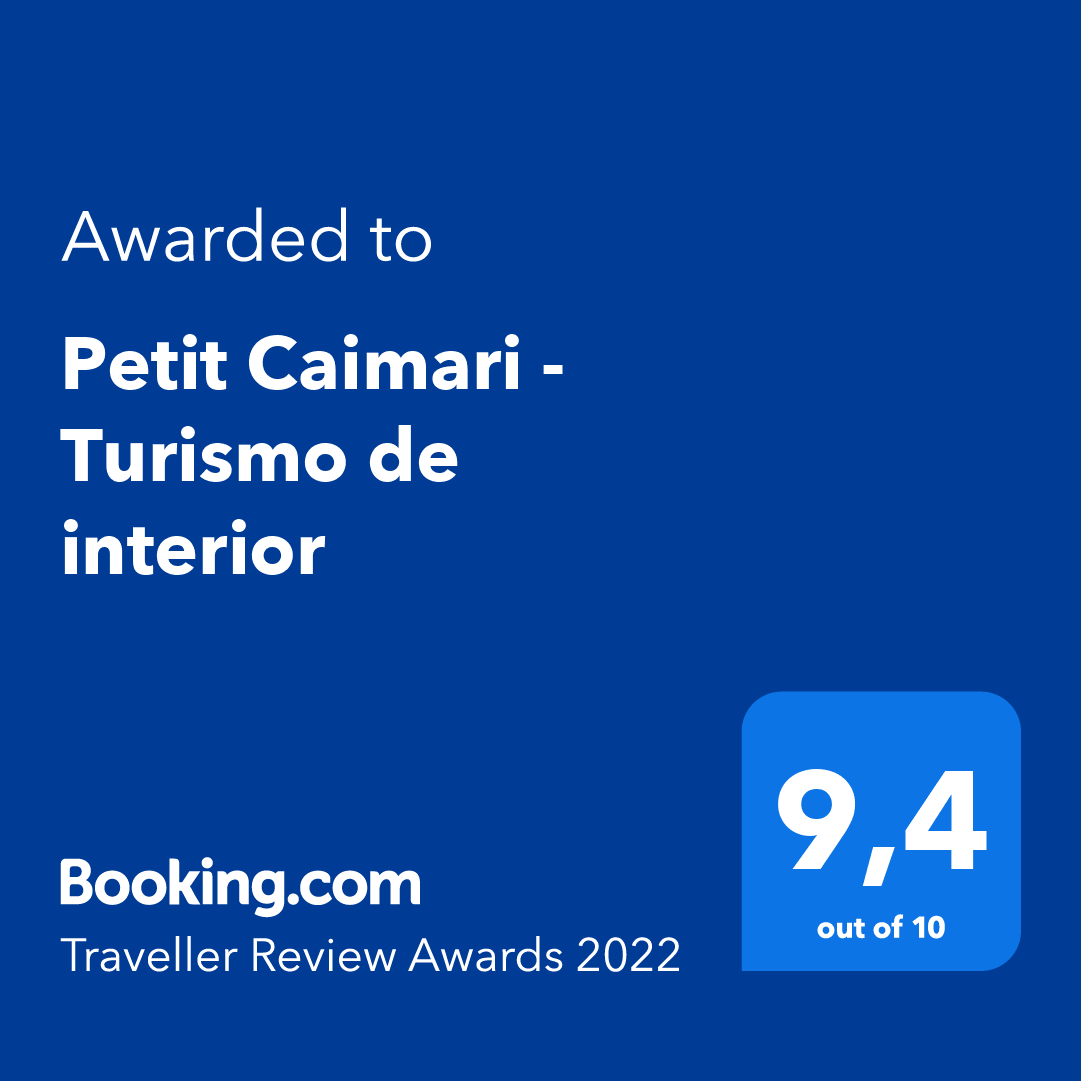 Award from Booking.com to Petit Caimari - Turismo de interior. Score 9.4 out of 10, blue background.