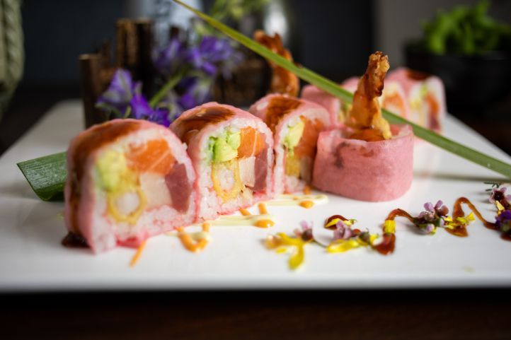 A close up of a plate of sushi on a table.