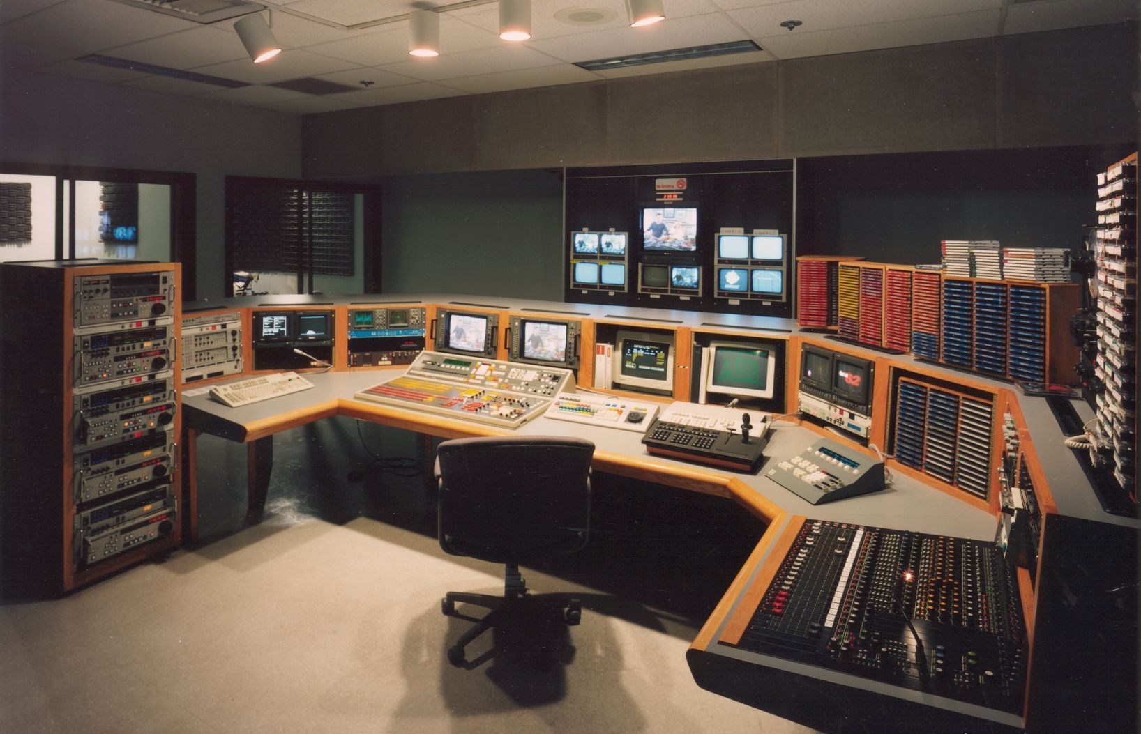 A control room with a lot of monitors and equipment